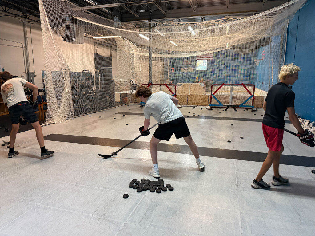Player shooting pucks into a net during a dryland session at Build Your Game